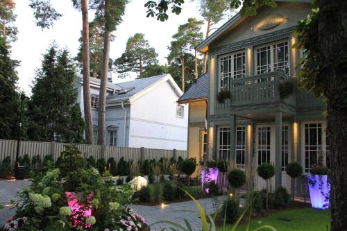 a house with a fence and a yard with flowers at Villa Lettonia in Jūrmala