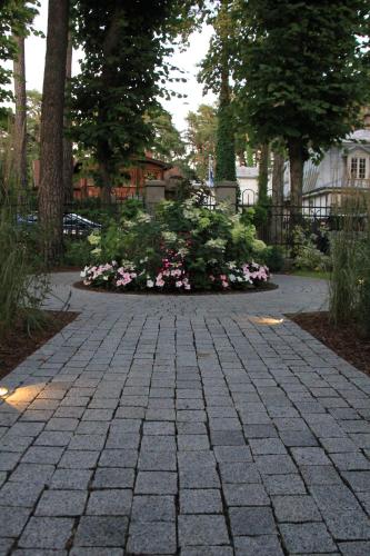 a stone walkway with flowers in a park at Villa Lettonia in Jūrmala