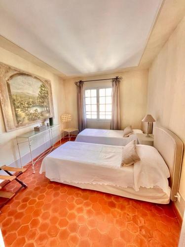 - une grande chambre avec un grand lit et une fenêtre dans l'établissement Chez Camille, à Saint-Tropez