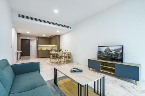a living room with a couch and a tv and a table at Eaton Residence KLCC in Kuala Lumpur