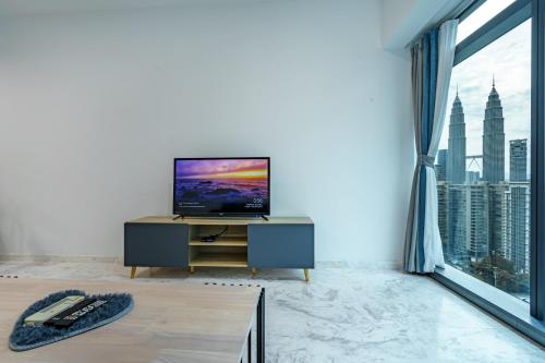 a living room with a tv and a large window at Eaton Residence KLCC in Kuala Lumpur