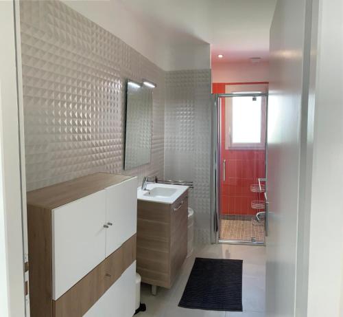 a bathroom with a sink and a red door at location 1 semaine minimum classé 3 étoiles in Aldudes