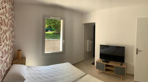 a bedroom with a bed and a tv and a window at location 1 semaine minimum classé 3 étoiles in Aldudes