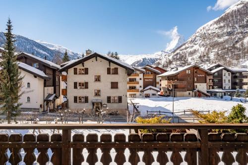 a view of a town with snow covered mountains at Haus Zer Weidu in Zermatt