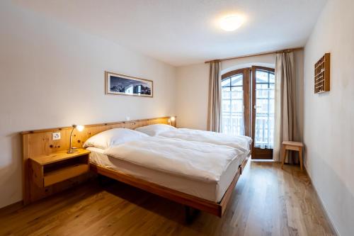 Un dormitorio con una cama grande y una ventana en Haus Zer Weidu, en Zermatt