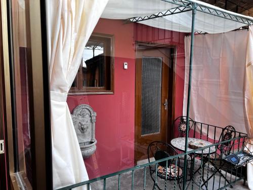 balkon domu z czerwoną ścianą w obiekcie CASA LINDNER Villa Rustico Ferienhaus 400m zum Gardasee 13Schlafplätze w mieście Toscolano Maderno