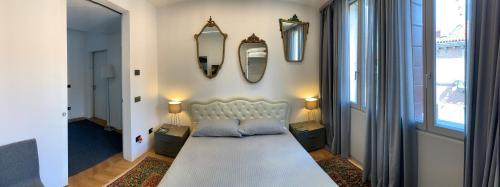 a living room with a white couch and a mirror at Suite Falier- Luminosa Venezia in Venice