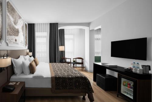a hotel room with a bed and a flat screen tv at Akka Suites Taksim-Special Class in Istanbul