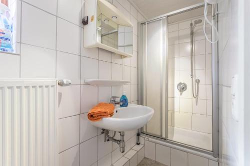 a white bathroom with a sink and a shower at Haus Rosi und Werner in Emmerting