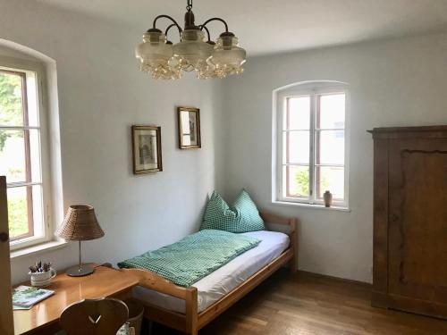 a bedroom with a bed and a table and windows at Haus Traundorf in Gmunden