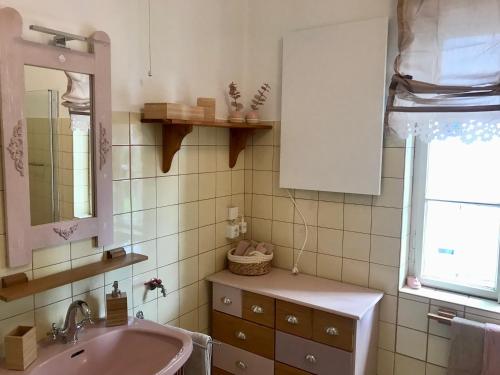 baño con lavabo rosa y espejo en Haus Traundorf, en Gmunden
