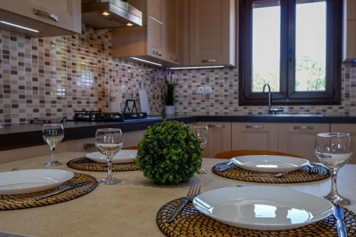 a kitchen table with plates and wine glasses on it at Casa Avgerinou in Afantou