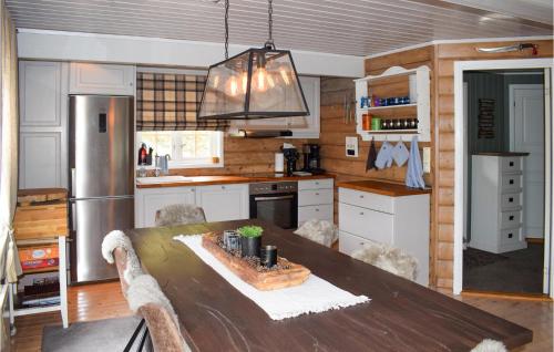 a kitchen with a wooden table and a refrigerator at Nice Home In Rjukan With Wifi in Rjukan