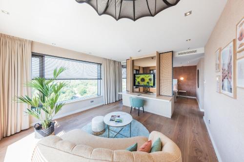 a living room with a couch and a table at Van der Valk Hotel Düsseldorf in Düsseldorf