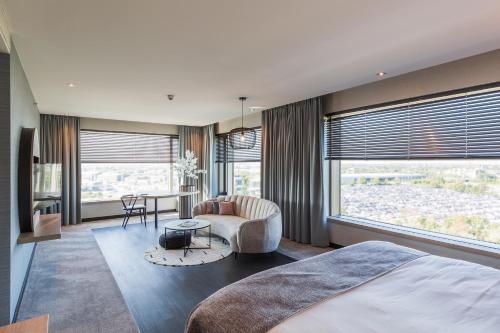a bedroom with a bed and a table and a chair at Van der Valk Hotel Düsseldorf in Düsseldorf