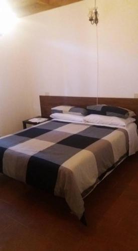 1 dormitorio con 1 cama con manta azul y blanca en La Casa Di Scrigno, en Poviglio