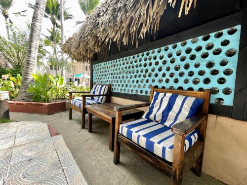 two chairs and a bench on a patio at Johnnys Place Hotel in Monterrico