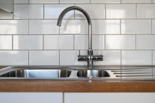a stainless steel kitchen sink with a faucet at The i360 flat, penthouse, sea view, large private roof terrace, central Brighton 2 bedroom, up to 6 guests in Brighton & Hove