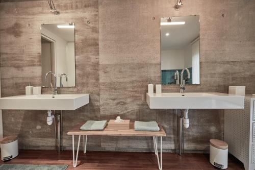 La salle de bains est pourvue de 2 lavabos et d'une table en bois. dans l'établissement LA PORTE ROUGE RBX, à Roubaix