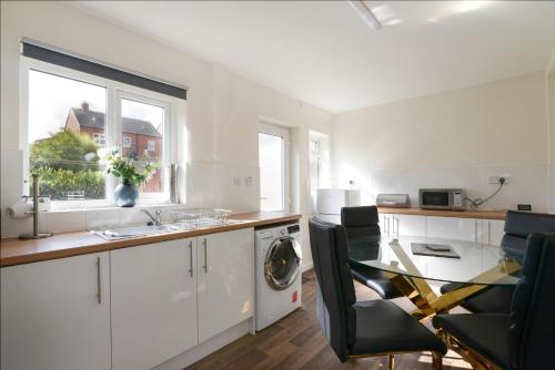 cocina con fregadero y mesa con sillas en Alderton House - Spacious 3 Bed with Parking en Nottingham