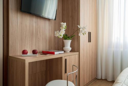 a room with a shelf with a vase with flowers on it at Hotel Re Enzo in Bologna