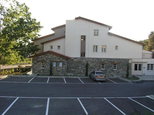 a building with a car parked in a parking lot at Livadia Hotel Kyperounta in Kyperounda