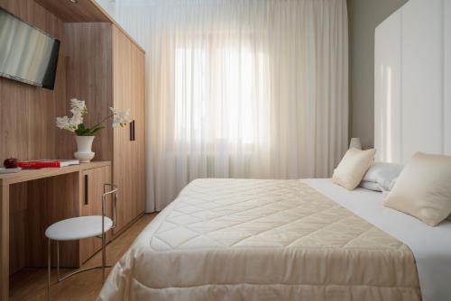 a hotel room with a bed and a television at Hotel Re Enzo in Bologna