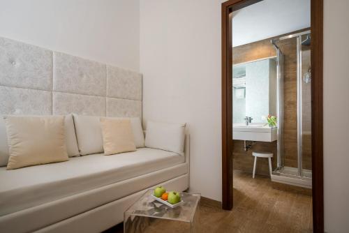 a living room with a white couch and a sink at Hotel Re Enzo in Bologna