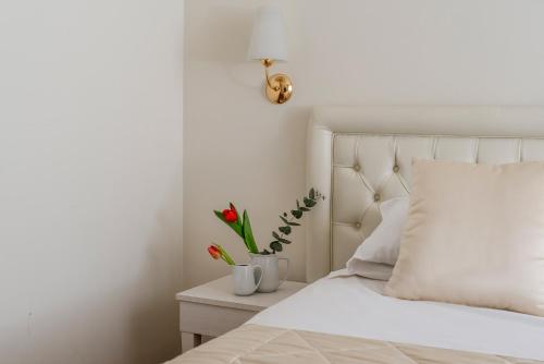 a bedroom with a white bed with red flowers on a nightstand at Hotel Re Enzo in Bologna