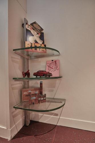 a glass shelf with books on a wall at LA PORTE ROUGE RBX in Roubaix
