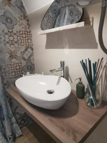 baño con lavabo blanco en una encimera de madera en Casa DiLù en Sannicola