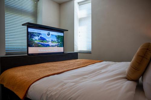 a bedroom with a bed with a flat screen tv at Hof van Hool in Nuenen