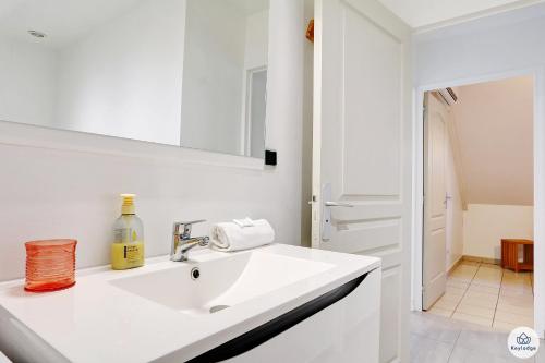 a white bathroom with a sink and a mirror at Amarena - 37m2 - Boucan Canot in Saint-Gilles les Bains