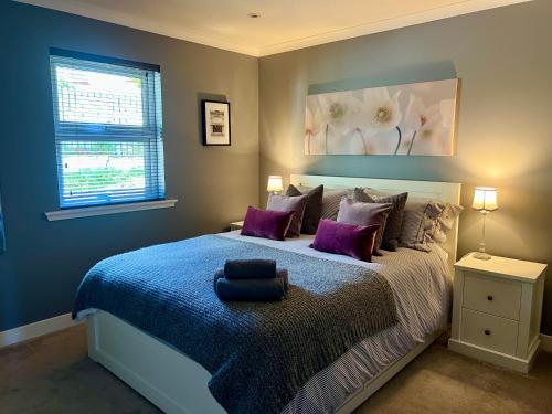 オーバンにあるHolly Lodge - Luxury Two Kingsize bedrooms with private entrance - entire placeのベッドルーム1室(大型ベッド1台、紫色の枕付)