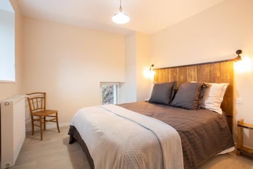 a bedroom with a large bed with a wooden headboard at Gîte de la Moulinquié in Saint-Cirgue