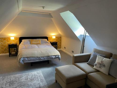 a bedroom with a bed and a couch at The Lodge at Briar house in Long Melford