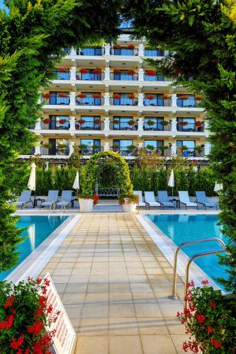 a hotel swimming pool with chairs and a building at Casa di Fiore SPA and Medical Hotel, Mineral Pools & Private Beach in Kranevo