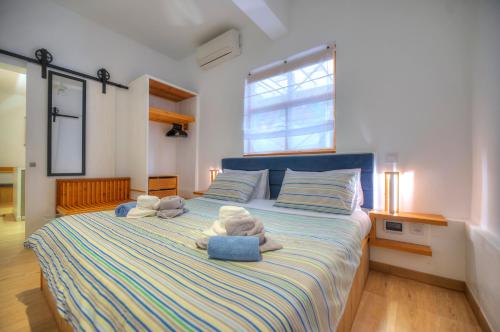 a bedroom with a large bed with stuffed animals on it at Eco-friendly & spacious 1bedroom townhouse PCUT1-1 in Il-Gżira