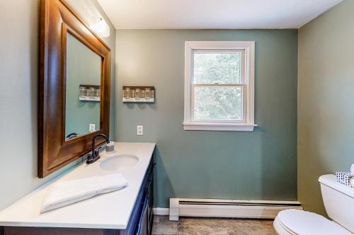 a bathroom with a sink and a mirror at Dream Dennis Getaway in Dennis
