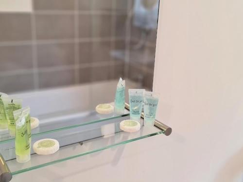 a glass shelf in a bathroom with towels and a mirror at Pass the Keys Modern Well Located New Build Apartment in Birmingham
