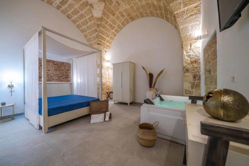 a bedroom with a bed and a tub in a room at Corte Janca in Montesano Salentino