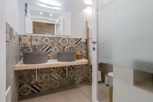 a bathroom with two sinks and a mirror at Corte Janca in Montesano Salentino