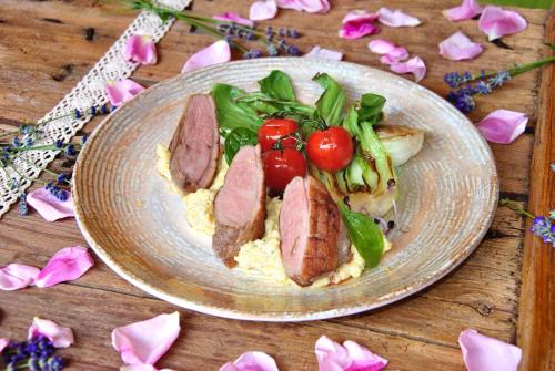 a plate of food with meat and vegetables on a table at Takler Kúria in Szekszárd