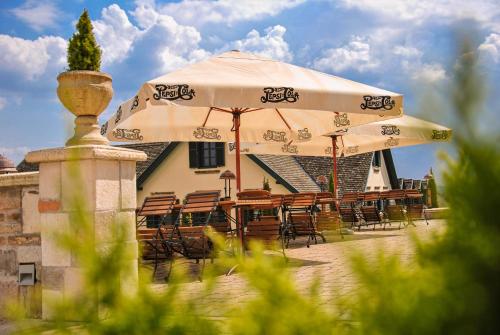 a group of tables and chairs under an umbrella at Takler Kúria in Szekszárd