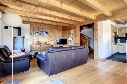 ein Wohnzimmer mit Ledermöbeln und Holzdecken in der Unterkunft Laiterie 1 in Verbier