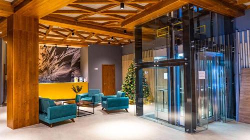 a lobby with blue chairs in a building at Redco"The Valley Residence & Spa" Bakuriani in Bakuriani