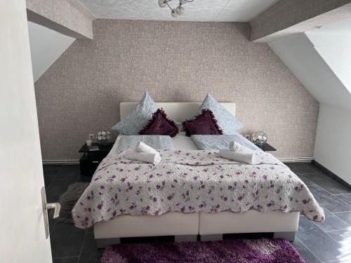- une chambre avec un grand lit et des oreillers violets dans l'établissement Schöne 3 Zimmer Wohnung, à Oberwesel