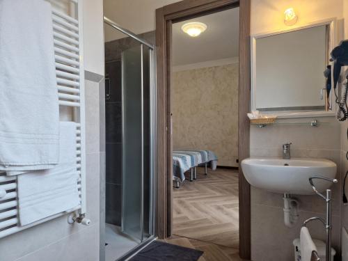 bagno con lavandino e doccia di Le Rustiche Foresteria a Dello