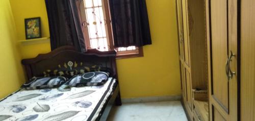 a bedroom with a bed in a yellow room at Srinivas Nilayam in Hyderabad