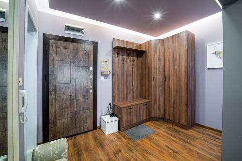 a hallway with a wooden door and wooden floors at Colibri Central Apartment in Varna City